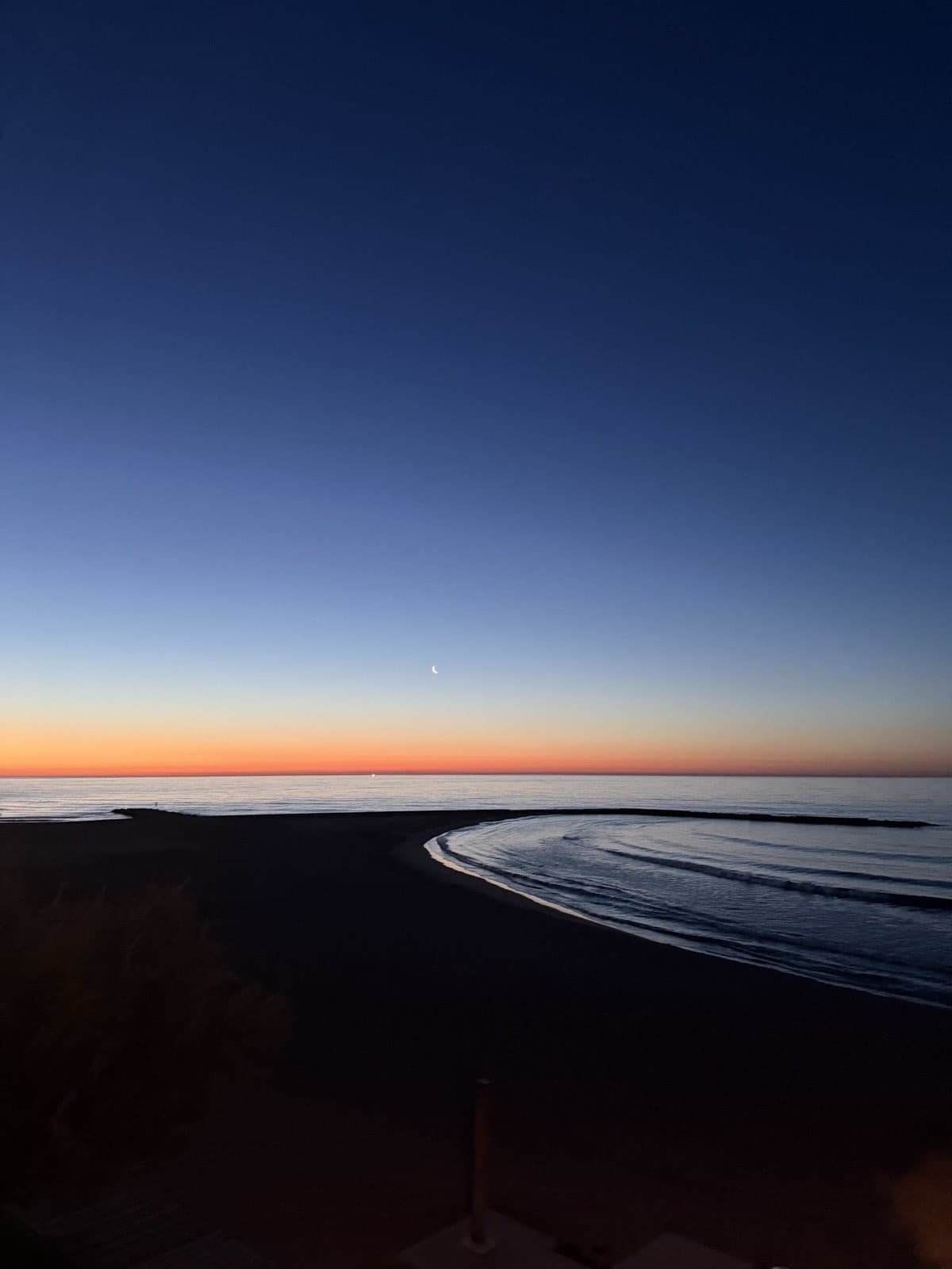 Zee-horizon met maan bij dageraad aan de Costa del Azahar